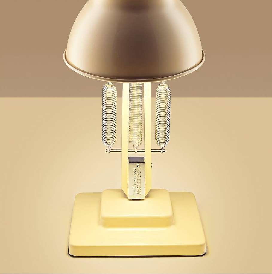 Close-up studio shot of a yellow Anglepoise lamp with springs, showcasing its design and functionality against a neutral background.