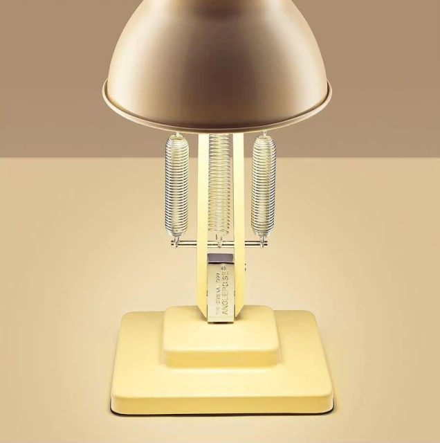 Close-up studio shot of a yellow Anglepoise lamp with springs, showcasing its design and functionality against a neutral background.