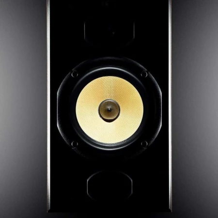 Close-up of a sleek, black speaker with a central yellow driver, showcasing modern audio equipment design.