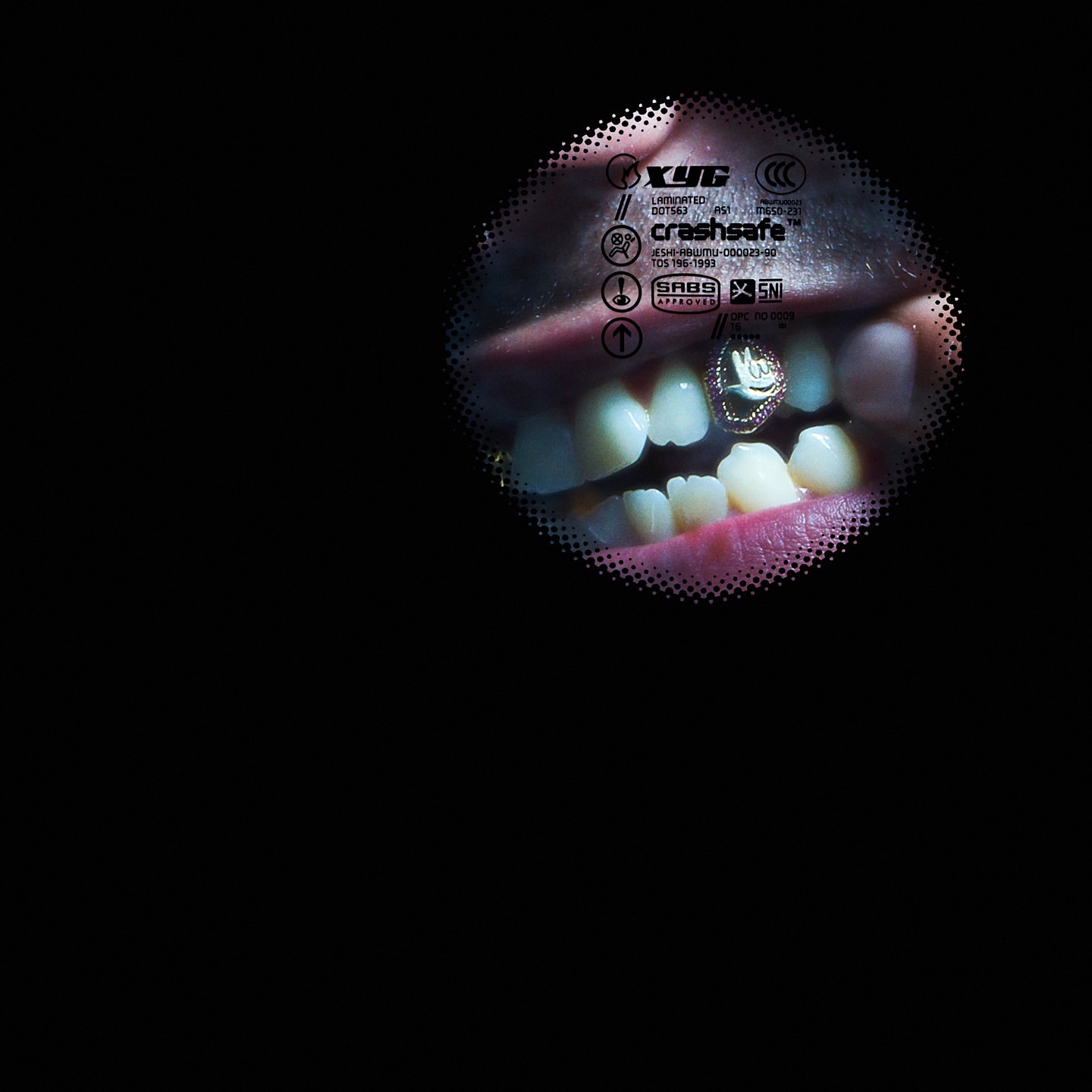 Close-up of a person's mouth showing teeth with a decorative grill on the lower teeth against a black background, focus on the teeth.