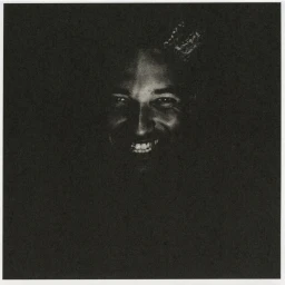 Close-up portrait of a smiling man emerging from deep shadows with heavy film grain and high contrast lighting.
