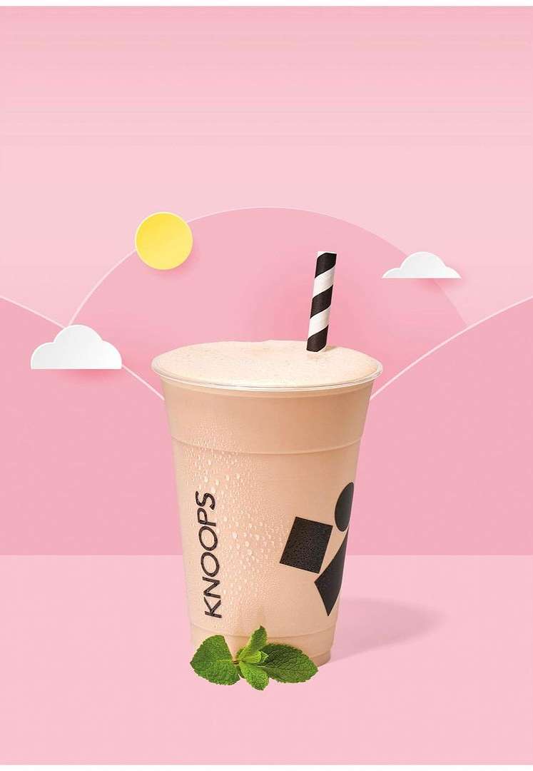 Beverage in clear plastic cup with Knoops logo and striped straw on pink background with paper cut out clouds and sun.