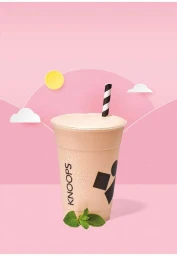Plastic cup of milkshake with black and white striped straw and mint garnish against a pink backdrop