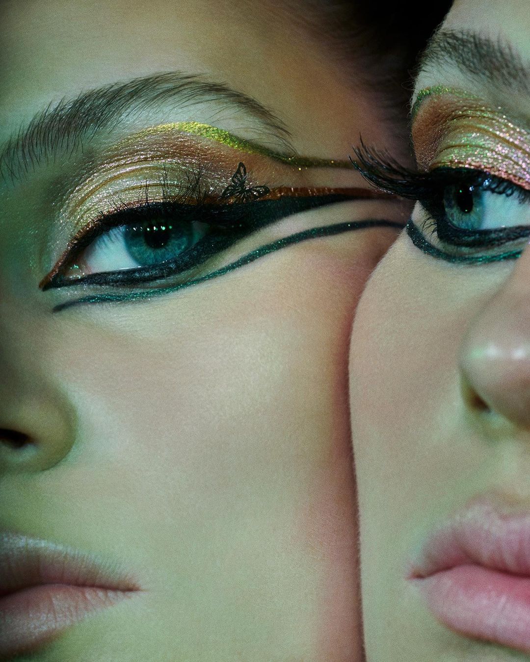 Extreme close-up of two adult females with blue eyes, light skin, dramatic eyeliner, and gold eyeshadow under green photo studio lighting.