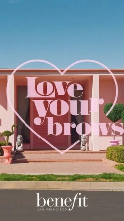 Exterior shot of a pink single-story house with a brown lawn and driveway, framed by a pale pink heart-shaped graphic overlay.