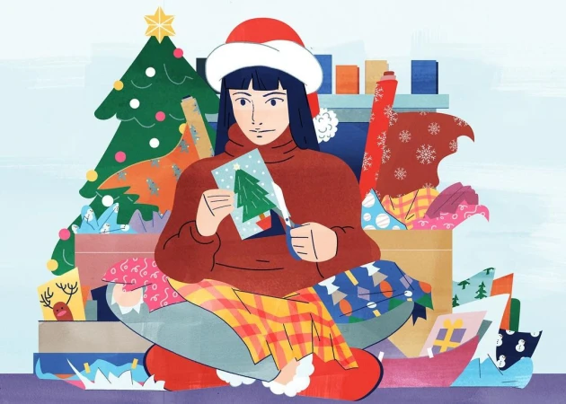 Illustration of a woman in a Santa hat sitting amid gifts and wrapping paper, cutting a Christmas tree card with scissors.