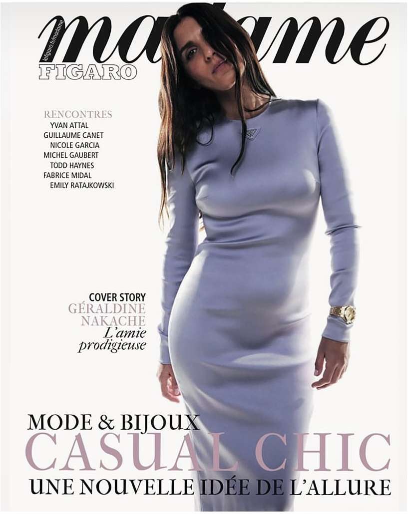 Magazine cover featuring a woman in a long-sleeved lilac dress, with dark hair, against a clean background with magazine text elements.