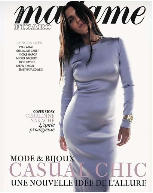 Magazine cover featuring a woman in a long-sleeved lilac dress, with dark hair, against a clean background with magazine text elements.