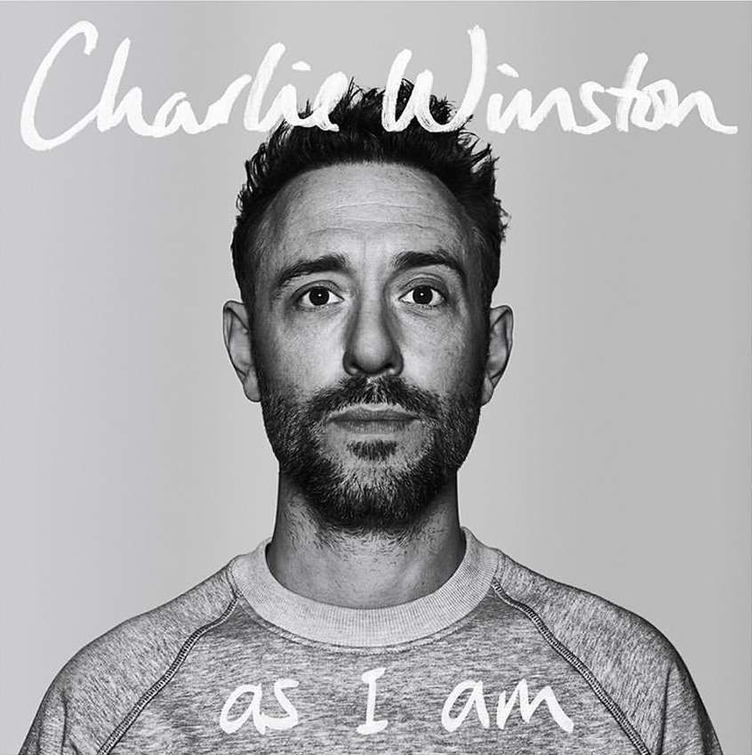 Black and white portrait of singer-songwriter Charlie Winston looking at the camera with a neutral expression, against a plain background.