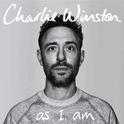 Portrait of Charlie Winston wearing a grey sweatshirt against a plain backdrop photographed in black and white by Jan Welters
