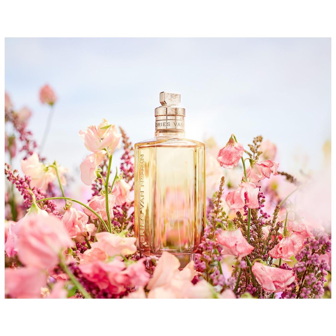 Elegant perfume bottle amidst pink flowers, evoking a fresh and floral scent for beauty and fashion campaigns.