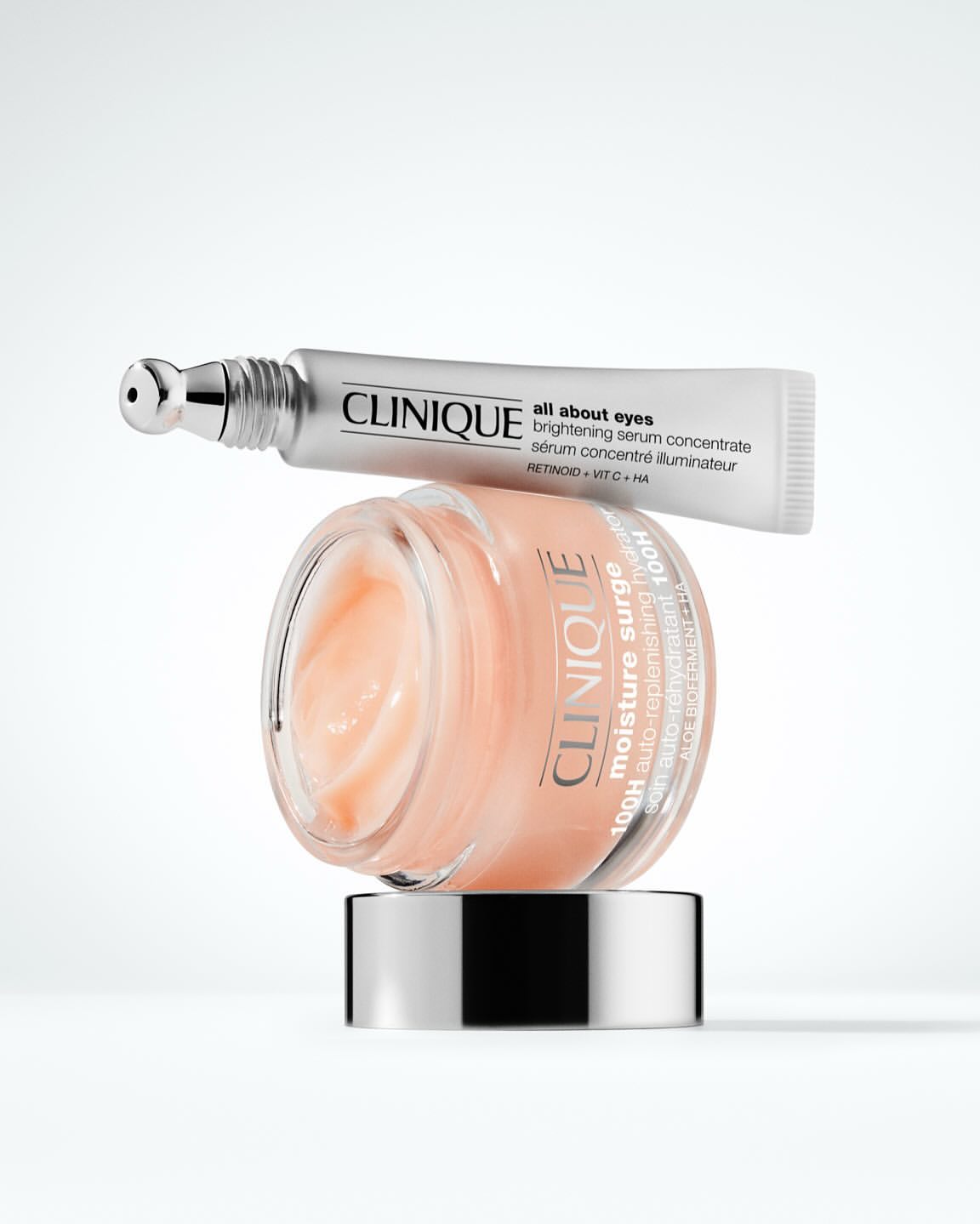 Two Clinique skincare products, including 'All About Eyes' serum and 'Moisture Surge' cream, arranged on a white background for beauty.