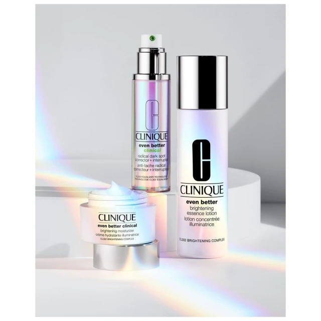 Three Clinique Even Better Clinical skincare products displayed against a light backdrop with prism light effect. Moisturizer, lotion, serum.