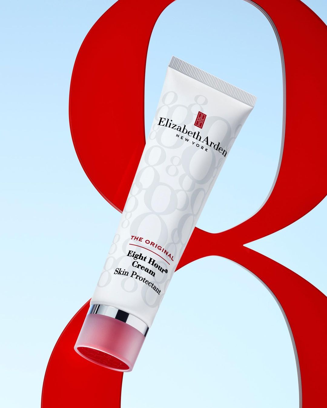 Elizabeth Arden Eight Hour Cream tube against a backdrop with a large red number eight and a soft blue gradient background.