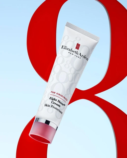 Elizabeth Arden Eight Hour Cream tube against a backdrop with a large red number eight and a soft blue gradient background.