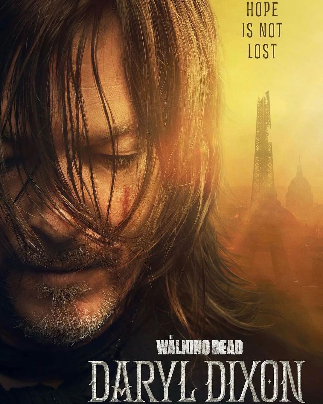 Close-up of Norman Reedus as Daryl Dixon against a post-apocalyptic backdrop, promoting 'The Walking Dead: Daryl Dixon' series.