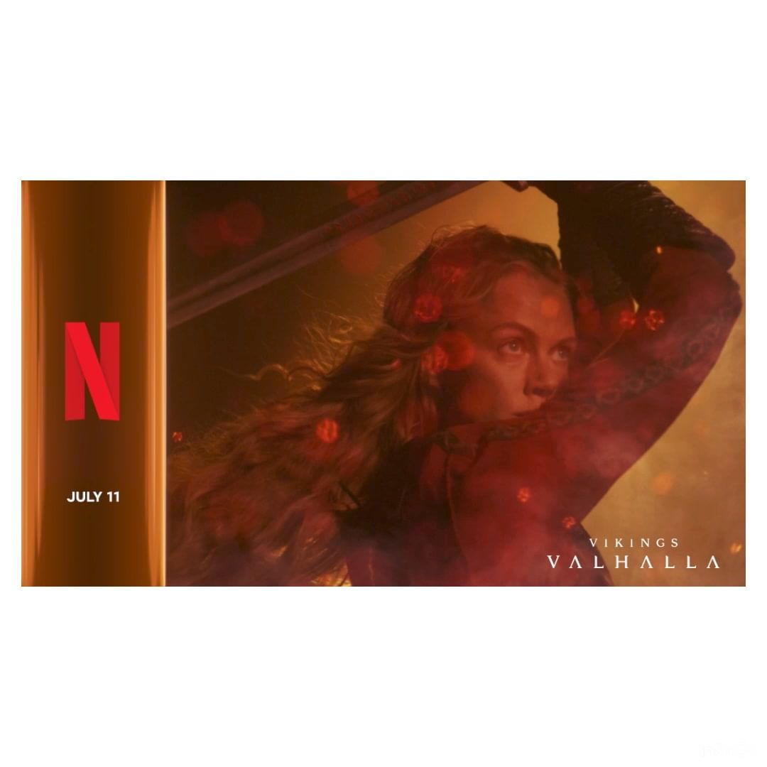 Adult woman with sword in Viking costume with blond hair. Netflix advertisement for Vikings Valhalla, set in muted yellow, red tones.