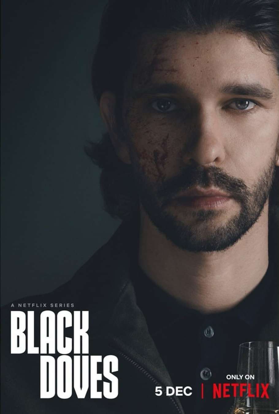 Close-up portrait of a man with a beard and dark hair, wearing a black shirt and jacket, promotional shot for Black Doves on Netflix.