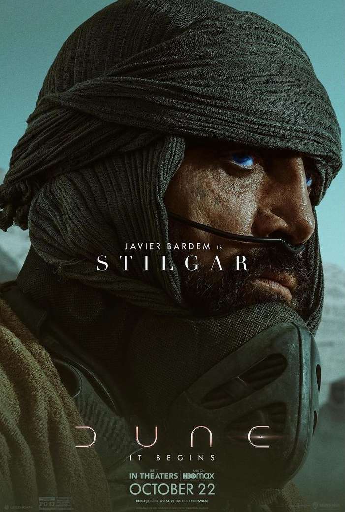 Movie poster of Javier Bardem as Stilgar in Dune: a close-up of a man in a head covering and mask with blue eyes, set against a tan background.