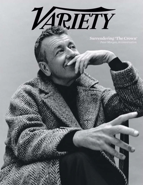 Black and white portrait of Peter Morgan on the cover of Variety, wearing a herringbone coat, resting his chin on his hand.