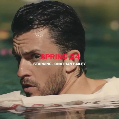 Close-up of adult male in a pool, looking off-camera. Red text SPRING 24, STARRING JONATHAN BAILEY are visible on the image.