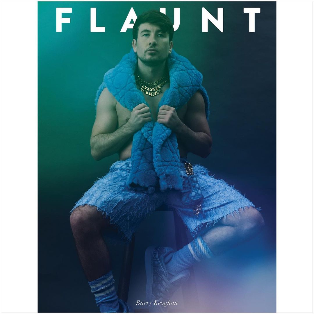 Barry Keoghan on magazine cover in blue shorts, blue scarf and gold chain, sitting on a white stool against a green gradient background.