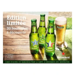 Three green Heineken beer bottles and a glass of beer on a wooden table outdoors with a sandy beach background.