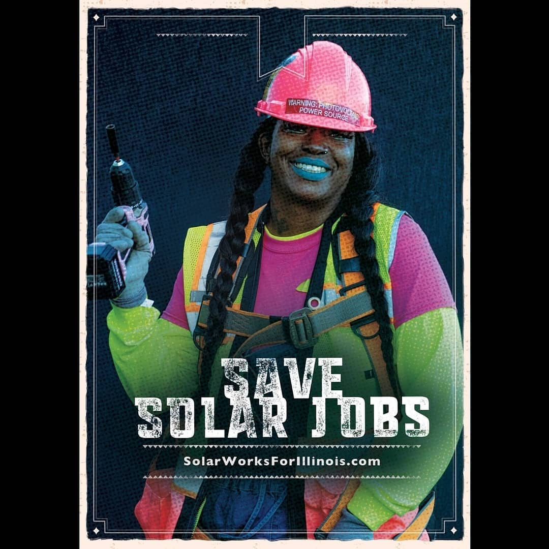 A woman in a hard hat and safety vest smiles while holding a drill in an advertisement to save solar jobs in Illinois.