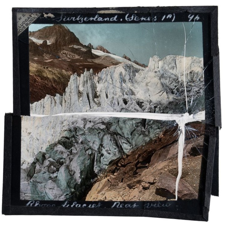 Old, colorized slide film of Switzerland's Rhone Glacier featuring a close view of its detailed icy formations and mountainous landscape.