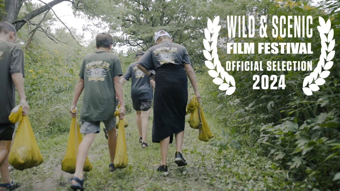 Group of people hikes on trail carrying yellow bags, outdoor, daytime. Wild & Scenic Film Festival Official Selection 2024 award graphic.