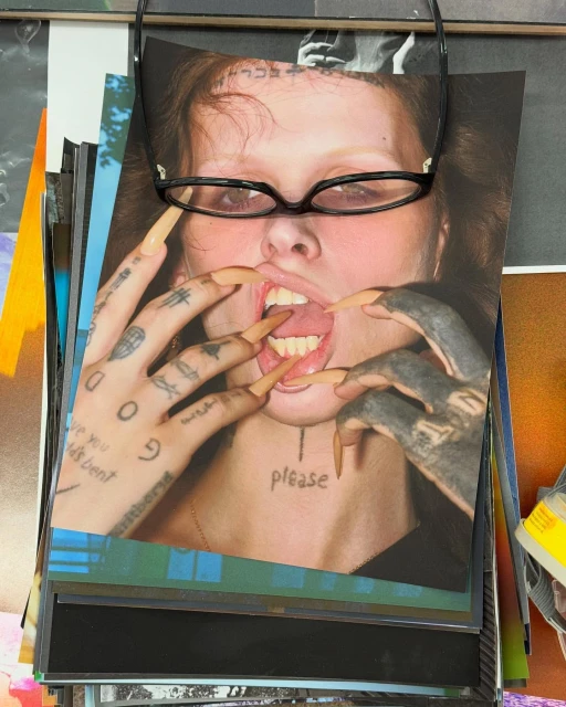 Stack of photographs featuring a woman with long nails and tattoos, along with a pair of glasses, showcasing editorial photography.