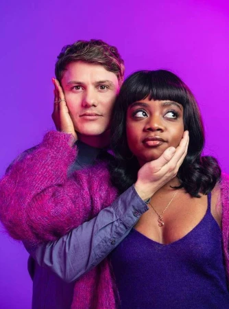 Portrait of a man and a woman posing closely together against a vibrant purple gradient background, photographed by Jay Brooks in London.