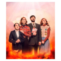 Portrait of a family of four posing with upward gazes against a fiery gradient background with light above.