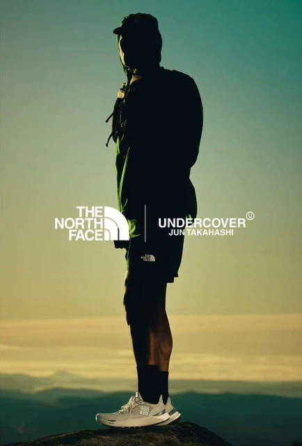 A person silhouetted against the sky wears athleisure apparel and running shoes, with The North Face Undercover Jun Takahashi logos.