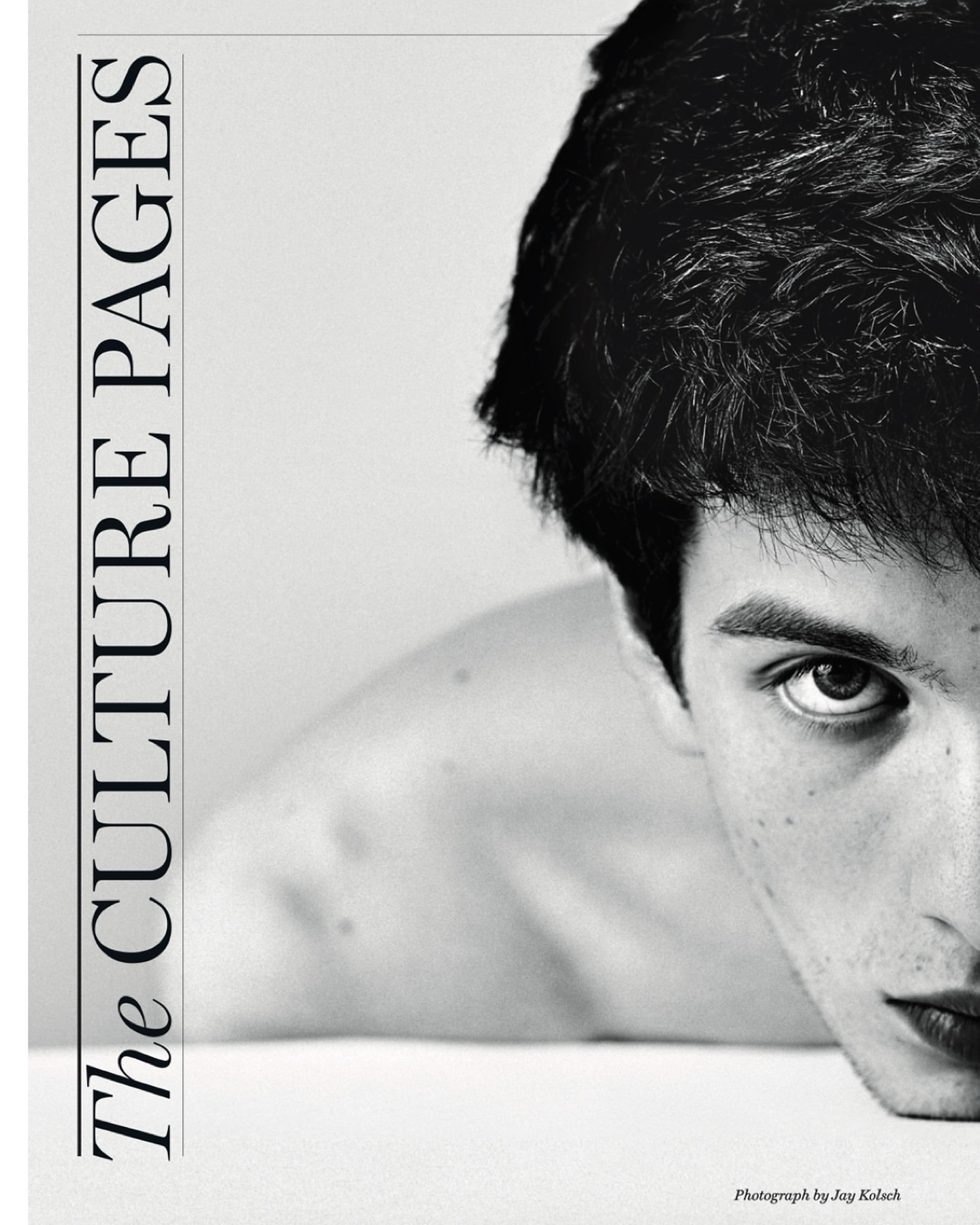Monochromatic portrait of a young adult male looking intently at the camera, with a magazine cover design on the left side of the frame.