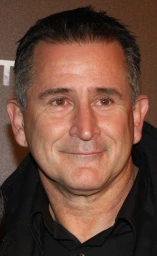 Close-up portrait of a smiling middle-aged man wearing a dark shirt in Sydney.