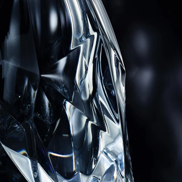 Close-up studio shot of a cut crystal object reflecting light against a dark background, showcasing its intricate geometric design.