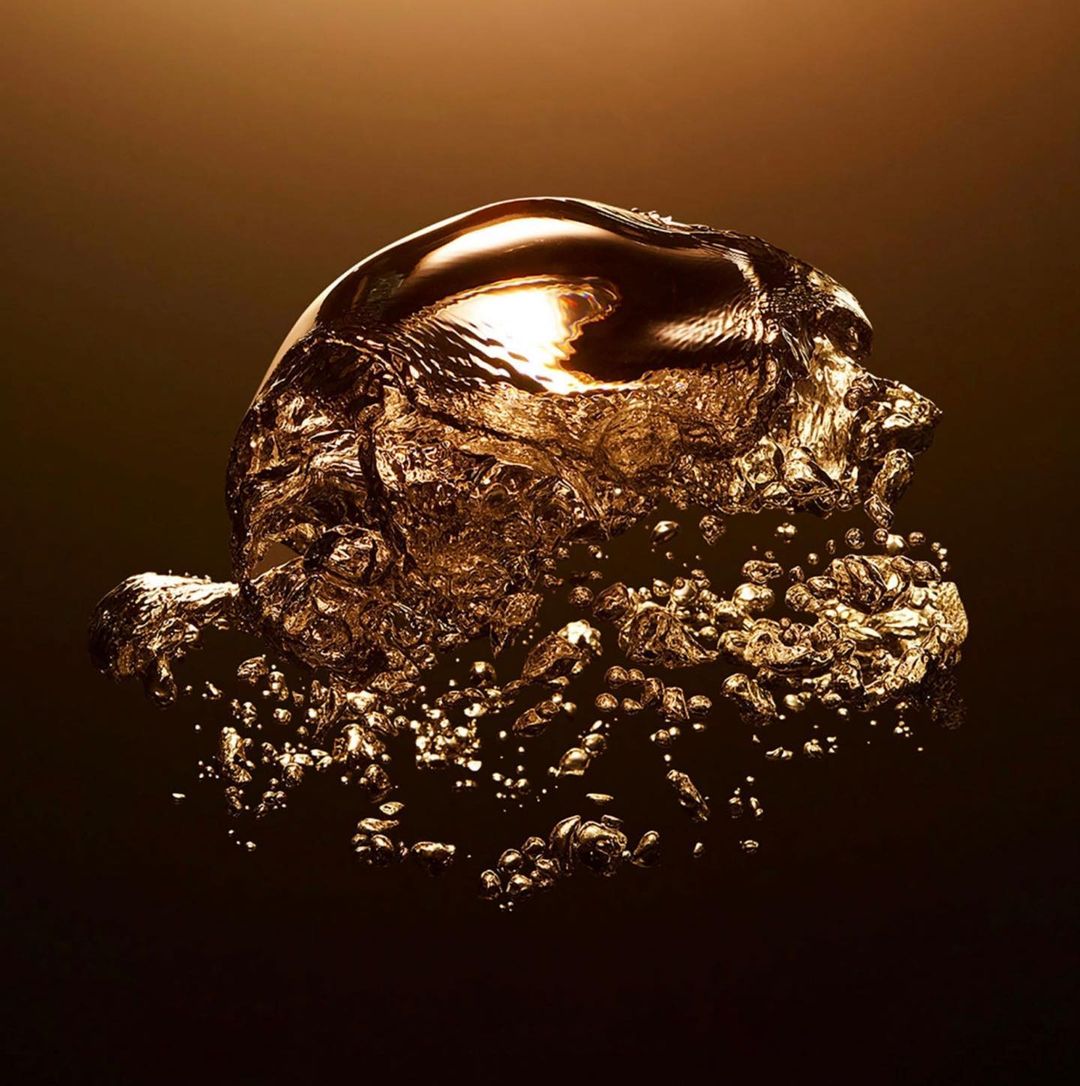 Abstract shot of a golden liquid bubble with a rough, textured surface, set against a dark brown background, emphasizing its fluid form.