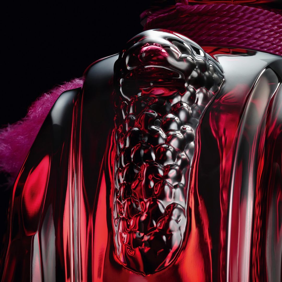 Close-up of a reflective, stylized sculpture in red and silver with a unique, textured design and a dark, contrasting background.