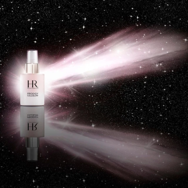 Cosmetic bottle of HR Prodigy Cellglow on a reflective surface against a background of pink light and scattered stars.