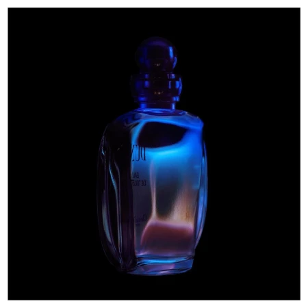Translucent perfume bottle stands out with blue and orange tones against a stark black backdrop, highlighting its sleek design.
