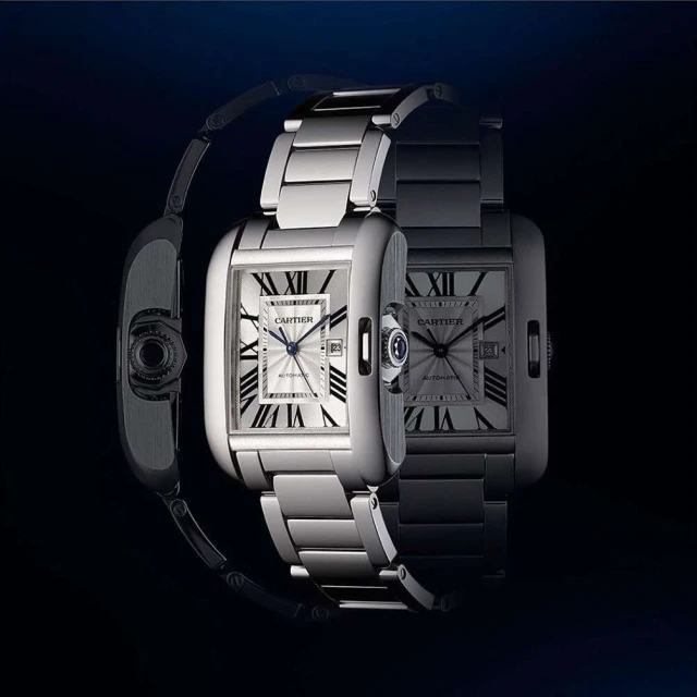 Elegant stainless steel Cartier Tank watch with a rectangular face, silver dial, and Roman numeral hour markers displayed in a studio setting.