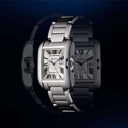 Elegant stainless steel Cartier Tank watch with a rectangular face, silver dial, and Roman numeral hour markers displayed in a studio setting.