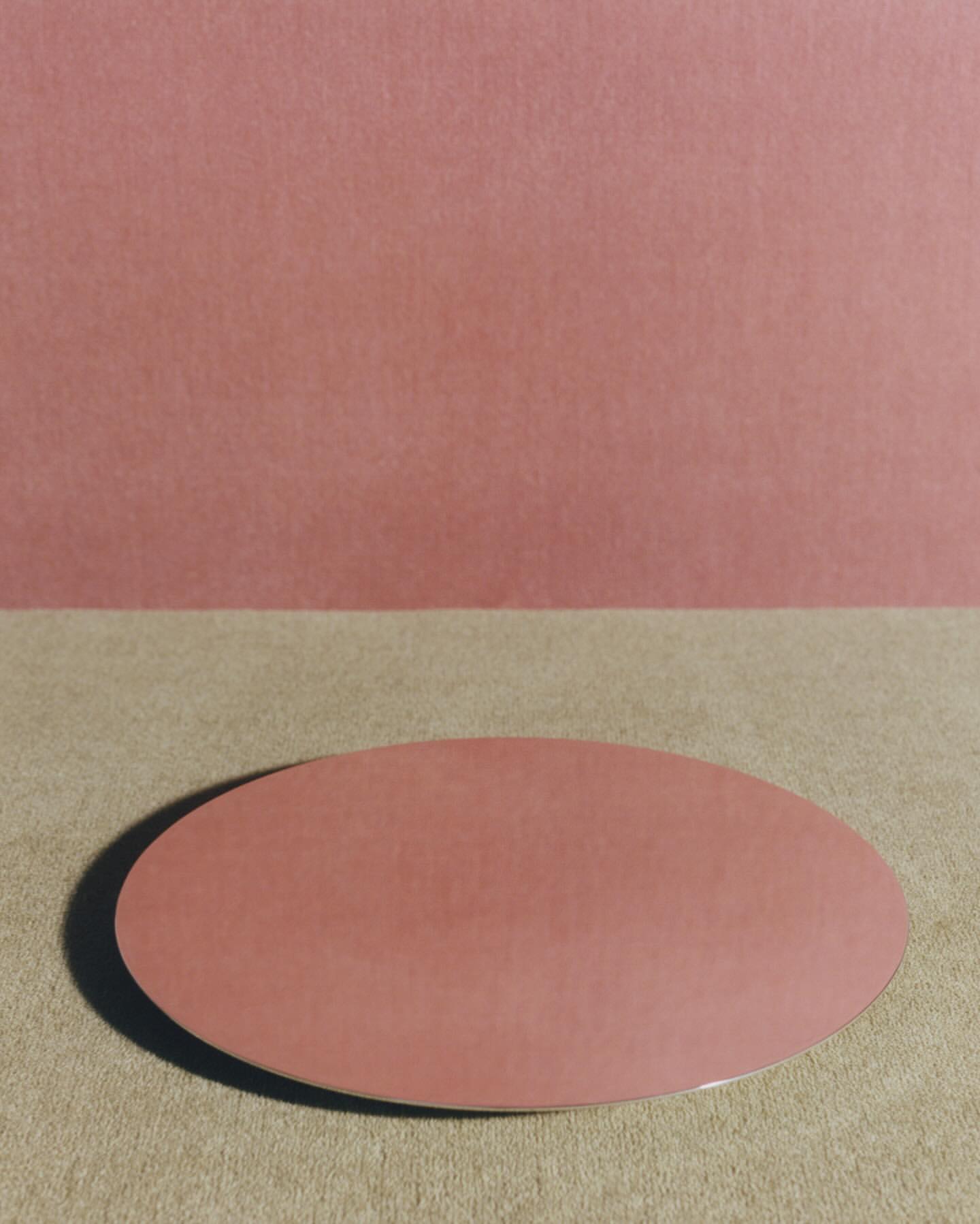 Minimalist studio shot of a pink oval against a pink backdrop, creating a monochromatic color palette with a modern, artistic aesthetic.