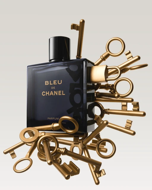Elegant studio shot of a Bleu de Chanel parfum bottle surrounded by antique gold keys, creating a luxurious and mysterious still life.