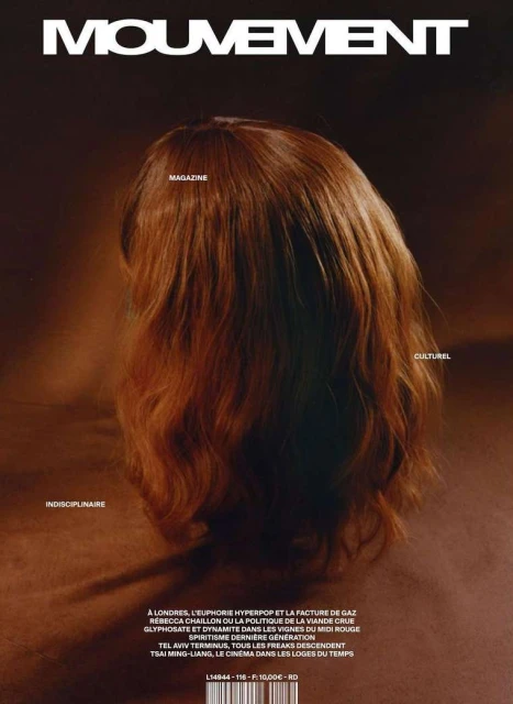 Magazine cover featuring a head with auburn hair, viewed from the back. The cover is cream and brown with magazine text and details.