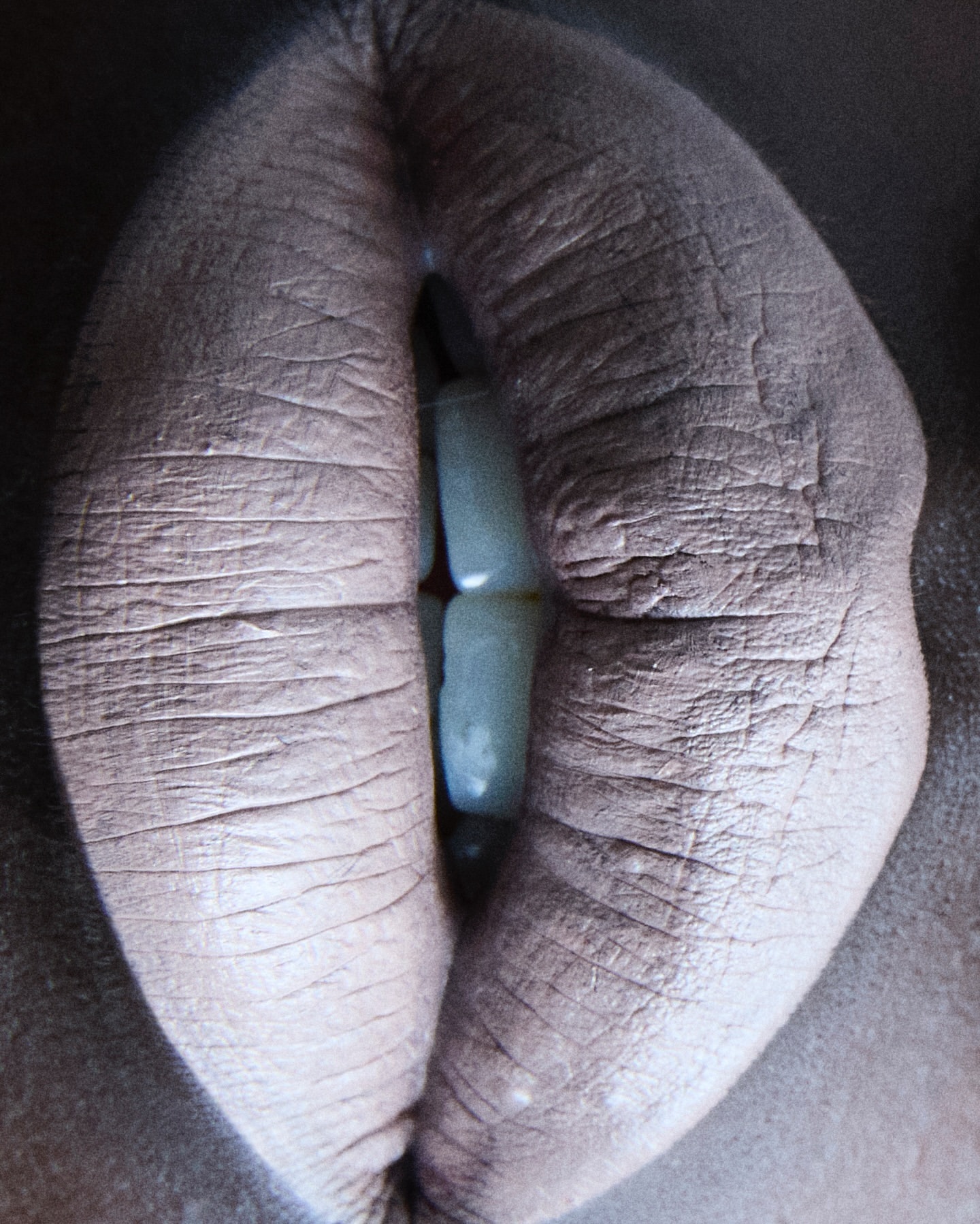 Close-up of a human mouth featuring lips with visible skin texture and teeth, captured in a high-detail composition.