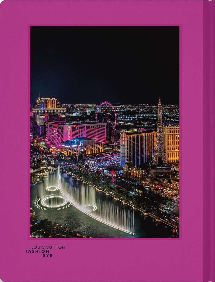 Nighttime aerial view of Las Vegas Strip featuring the Bellagio fountains, hotels, and the Eiffel Tower replica with a magenta frame.