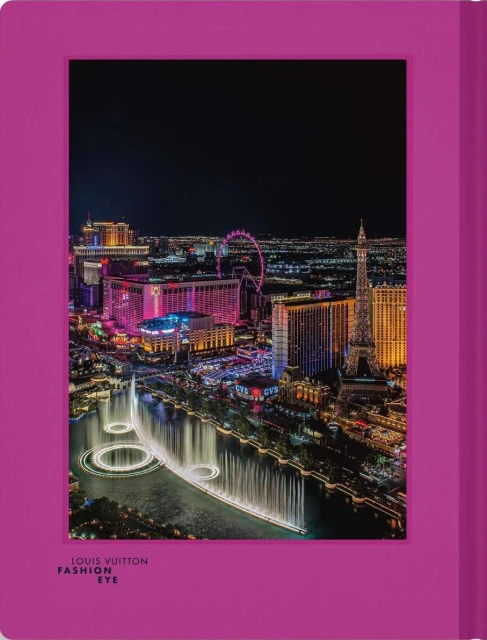 Nighttime aerial view of Las Vegas Strip featuring the Bellagio fountains, hotels, and the Eiffel Tower replica with a magenta frame.