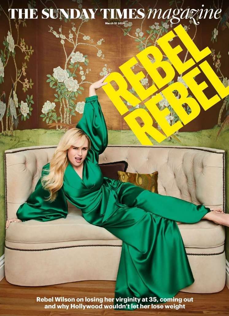 Magazine cover featuring Rebel Wilson in a green satin dress on a cream couch against a floral backdrop with yellow text overlay.